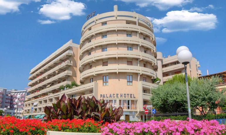 Hotel moderno con fiori colorati e cielo blu.