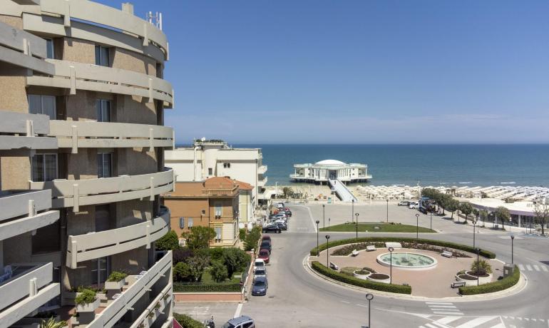 Vista sul mare con edificio moderno e rotonda.