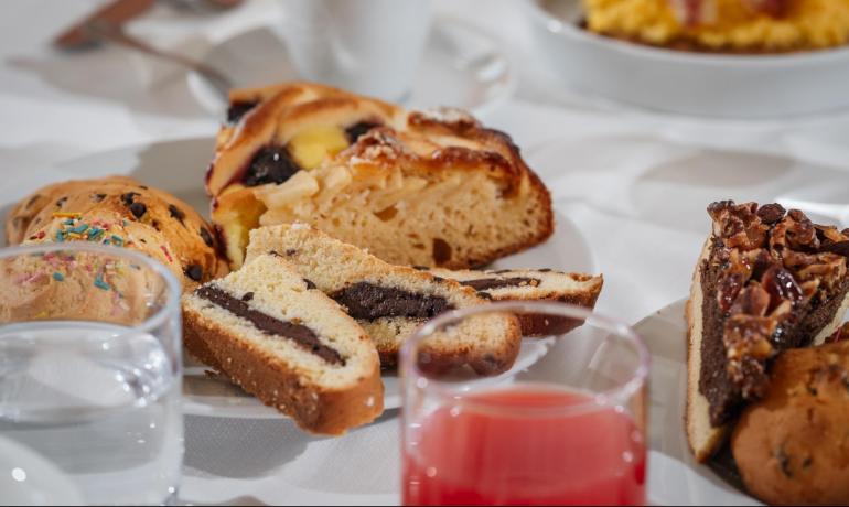 Colazione con dolci assortiti e bevande su un tavolo.