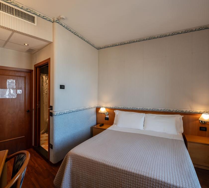 Camera d'albergo accogliente con letto matrimoniale e bagno privato.