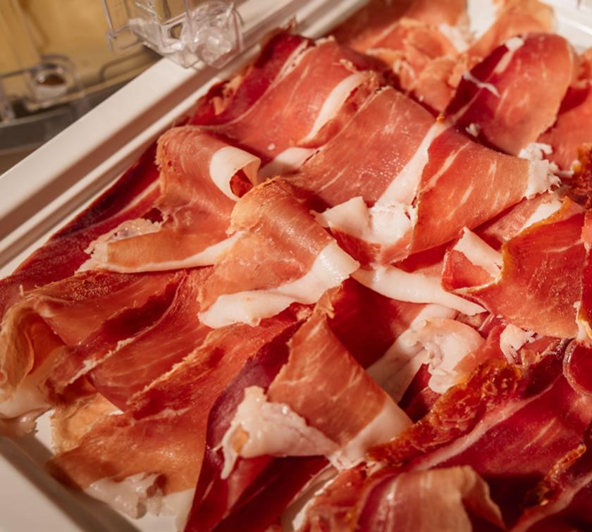 Fette di prosciutto crudo su un vassoio, pronte per essere servite.