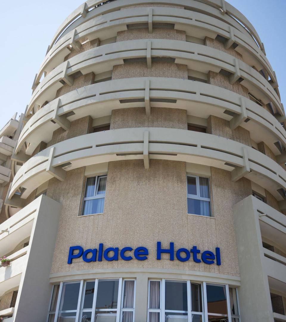 Edificio moderno con balconi, Palace Hotel, cielo azzurro sullo sfondo.